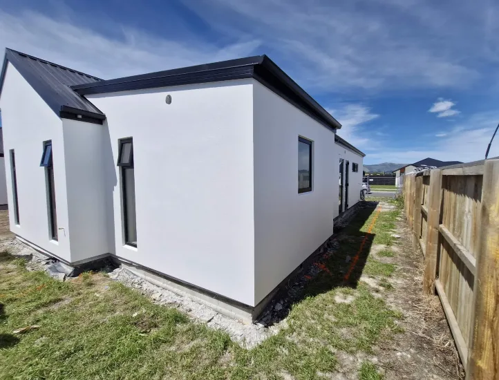 Single-storey home with fresh white render and dark roof